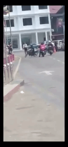 Policeman kicks motorcyclist