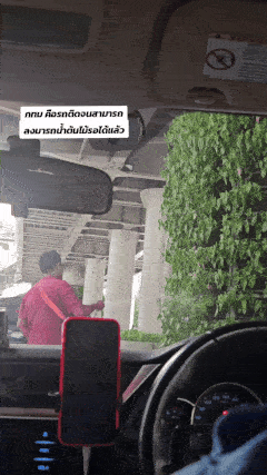 man waters plants in bangkok traffic