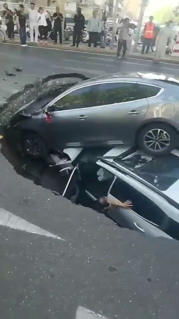 sinkhole china 2 vehicles atop
