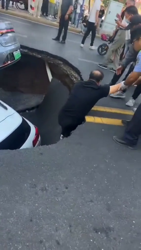 sinkhole china 2 vehicles climbing