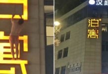 man hanging hotel signboard