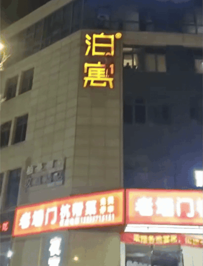 man hanging hotel signboard