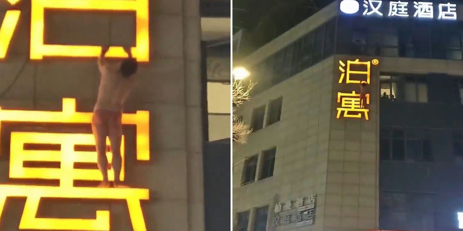 man hanging hotel signboard