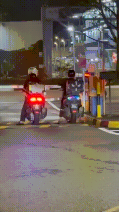 two motorcycles waiting by a gantry