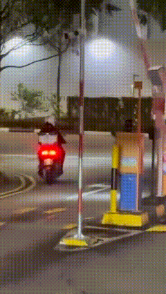 two motorcyclists riding out the gantry at the same time