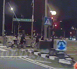 two cyclists at a traffic light with no helmets on