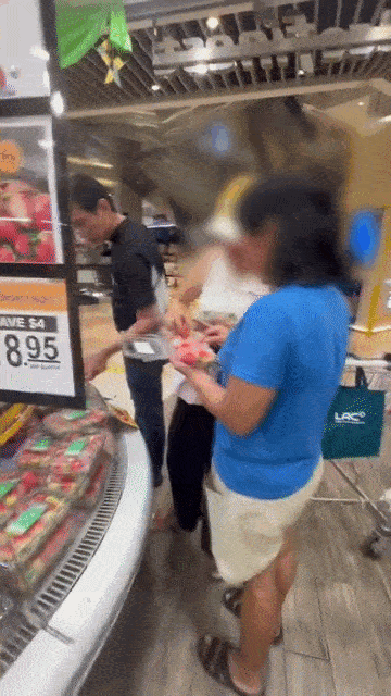 woman opens box of strawberries