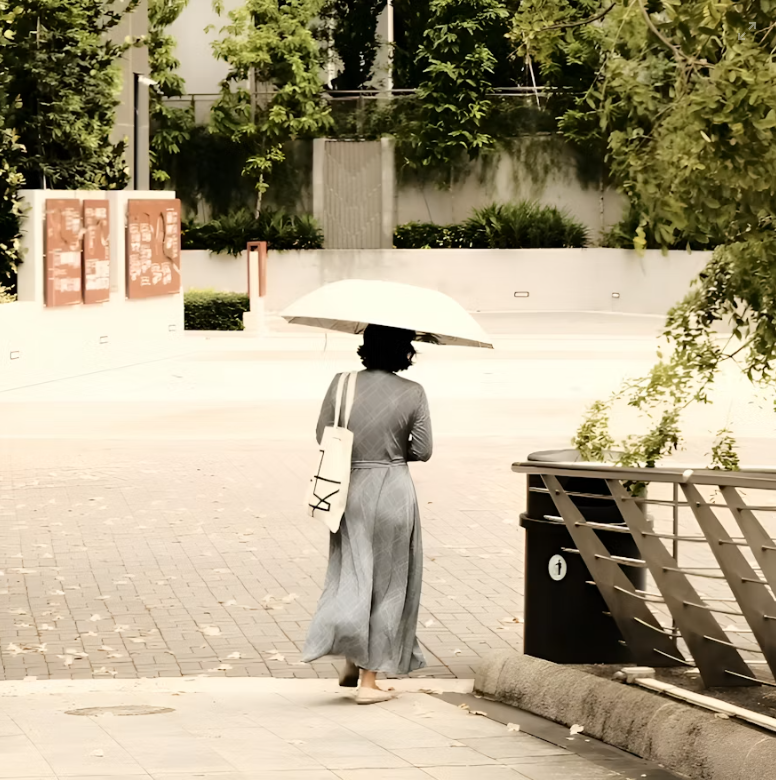 woman carrying umbrella to shade from heat