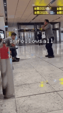 man squats airport